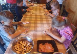 Dzieci formują ciasto na pizzę