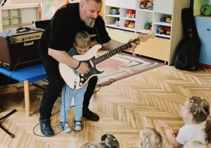 chłopiec gra na gitarze