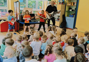 dzieci wraz z Panem grają na gitarach elektrycznych