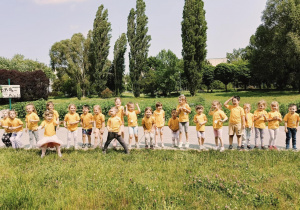 dzieci pozują do zdjęcia grupowego z medalami