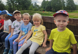 dzieci jadą na przyczepie traktora na wycieczkę po terenie gospodarstwa
