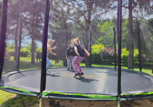 dzieci skaczą na trampolinie