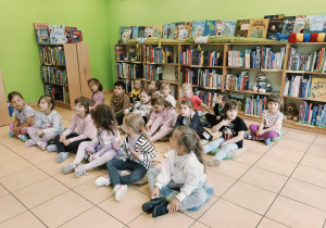 dzieci słuchają książki czytanej przez Panią bibliotekarkę