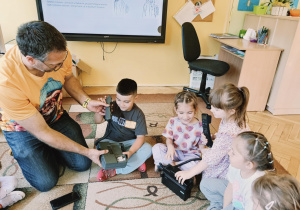 dzieci słuchają ciekawostek na temat sposobów komunikowania się ludzi z dawnych czasów