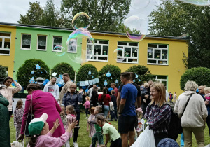 dzieci i rodzice podczas puszczania baniek mydlanych