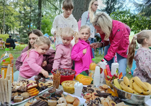 dzieci wraz z rodzicami przy słodkim poczęstunku