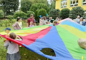 dzieci i rodzice podczas zabaw z chustą animacyjną