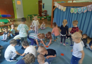 Dzieci biorą udział w zabawie ruchowej, omijając kolorowe kropki