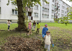 dzieci szukają śmieci na trawniku