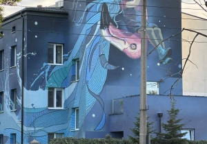 uczestnicy gry terenowej oglądają mural na budynku Fundacji Gajusz