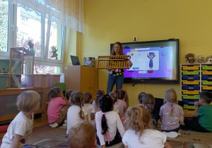 prowadząca objaśnia dzieciom działanie liczydła