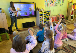 dzieci rozwiązują zadanie matematyczne na monitorze edukacyjnym