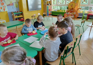 dzieci kroją i obierają owoce