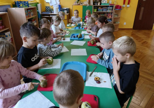 dzieci kroją i obierają owoce