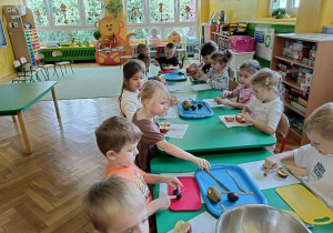 dzieci kroją i obierają owoce