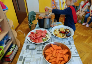 dzieci wyciskają sok z owoców