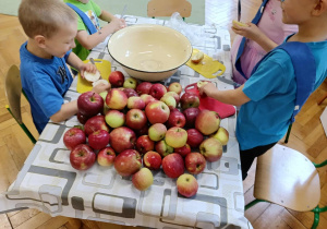 dzieci obierają i kroją jabłka