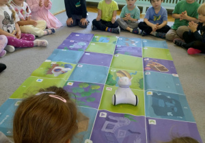 dzieci programują trasę jaką ma pokonać robot na macie do kodowania