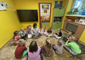 dzieci słuchają czytanej przez mamę Klary książki