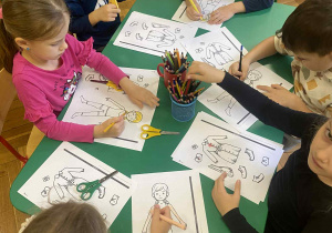 dzieci w przy stolikach wykonują prace plastyczne