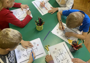 dzieci w przy stolikach wykonują prace plastyczne