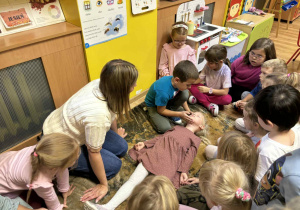 Dzieci na sobie na wzajem ćwiczą jak zabezpieczyć miejsce udzielania pomocy, sprawdzić czy osoba poszkodowana jest przytomna i czy oddycha.