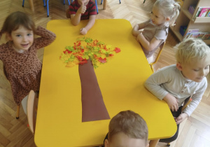 Dzieci układają drzewa wykorzystując jesienne liście