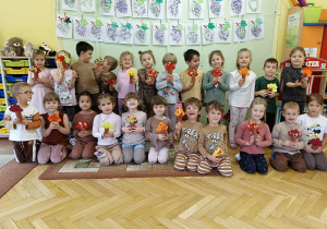 grupa dzieci pozuje do zdjęcia ze swoimi pracami
