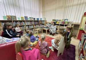 dzieci słuchają książki o zwierzętach czytanej przez p. Małgosię