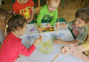 Dzieci malują na powierzchni pokrytej mydłem