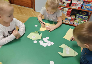 Dzyeci skladaja pieska metodą origami.