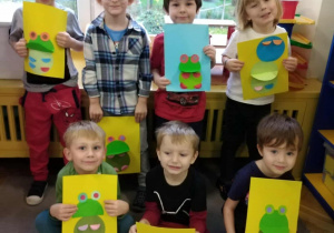 Chłopcy z grupy zielonej ustawieni do zdjęcia prezentują swoje prace.