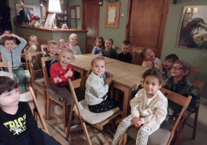 Dzieci siedzą na miejscach i oczekują na rozpoczęcie przedstawienia.