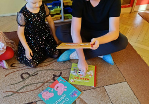 Pan Artur wraz z dziećmi ustala kolejność czytanej książki