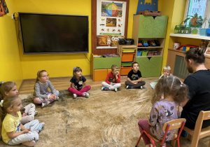 tata Idy czyta dzieciom książkę