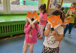 Dzieci z masķą liska chodzą po dywanie