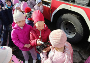 Dzieci oglądają końcówkę węża strażackiego