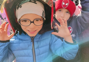 Dzieci przymierzają kaski strażackie.