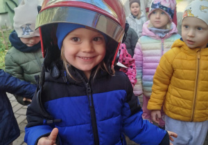 Dzieci przymierzają kaski strażackie.