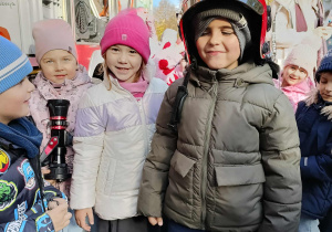 Dzieci przymierzają kaski strażackie.