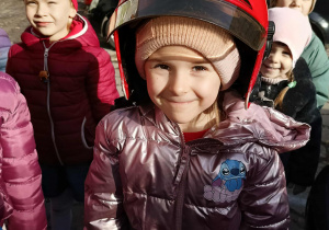 Dzieci przymierzają kaski strażackie.