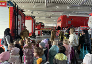 uczestnicy wycieczki oglądają wyposażenie w budynku straży pożarnej.