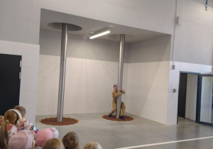 Dzieci patrzą jak Strażak demonstruje zjazd z rury strażackiej.