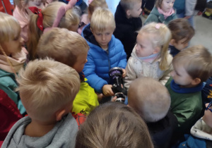 Dzieci sprawdzają jak wyglądają i ile ważą sprzęty używane w akcjach przez Strażaków.