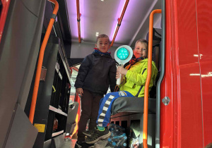 dzieci siedzą w kabinie wozu strażackiego