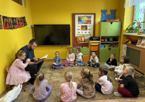 tata Lenki czyta dzieciom książkę